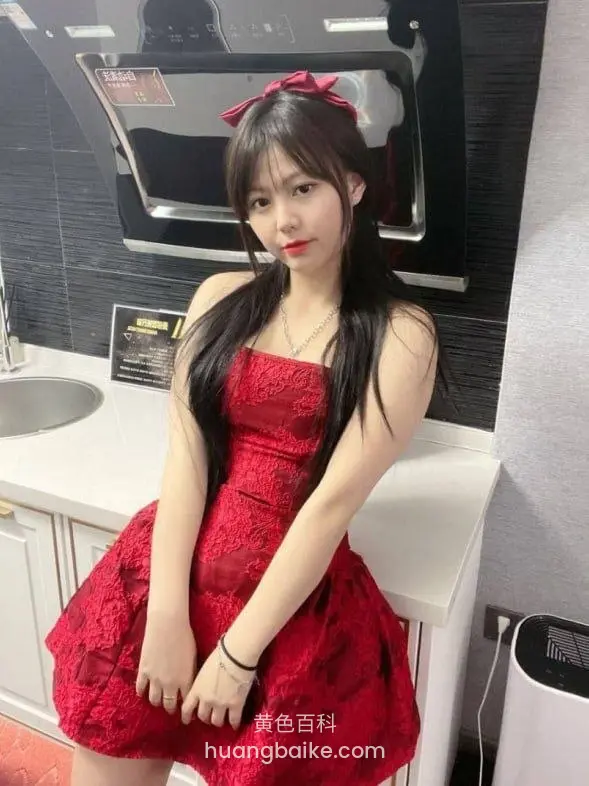 厨房台边双手交叠，身后油烟机和水槽