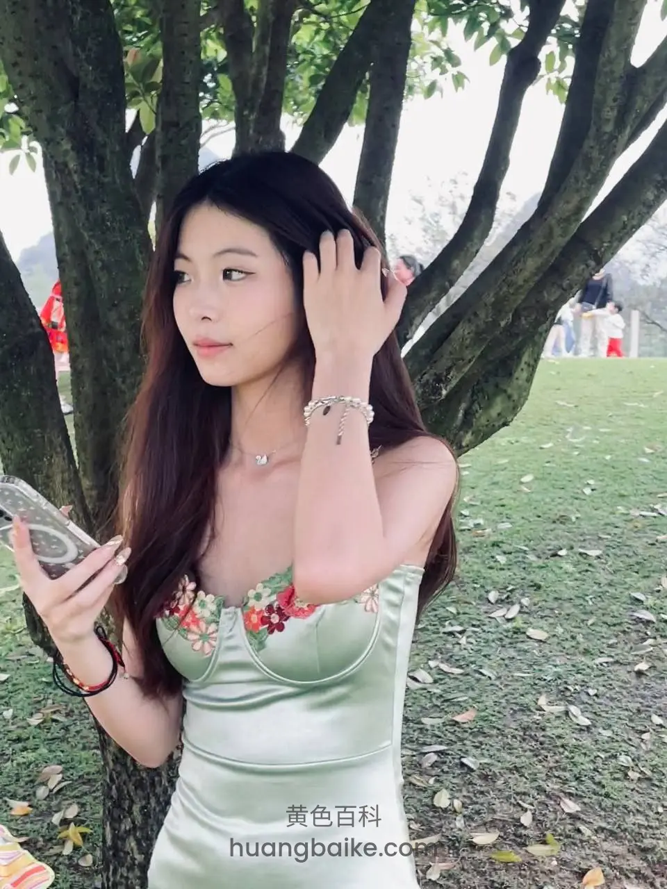 公园树下拿手机理头发