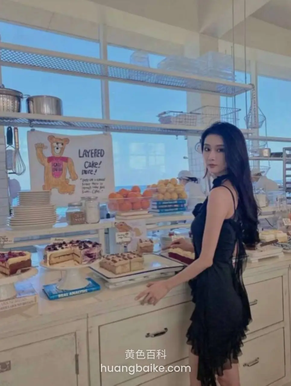 甜品店柜台前，身后一排蛋糕和LAYERS CAKE招牌