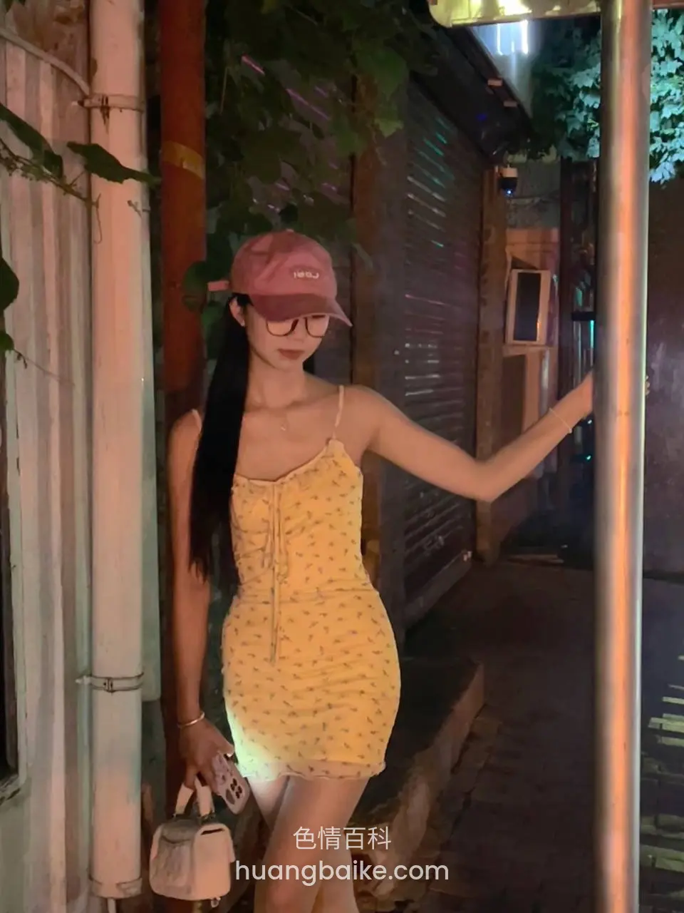 夜巷里靠着柱子，左手提白色包右手扶杆