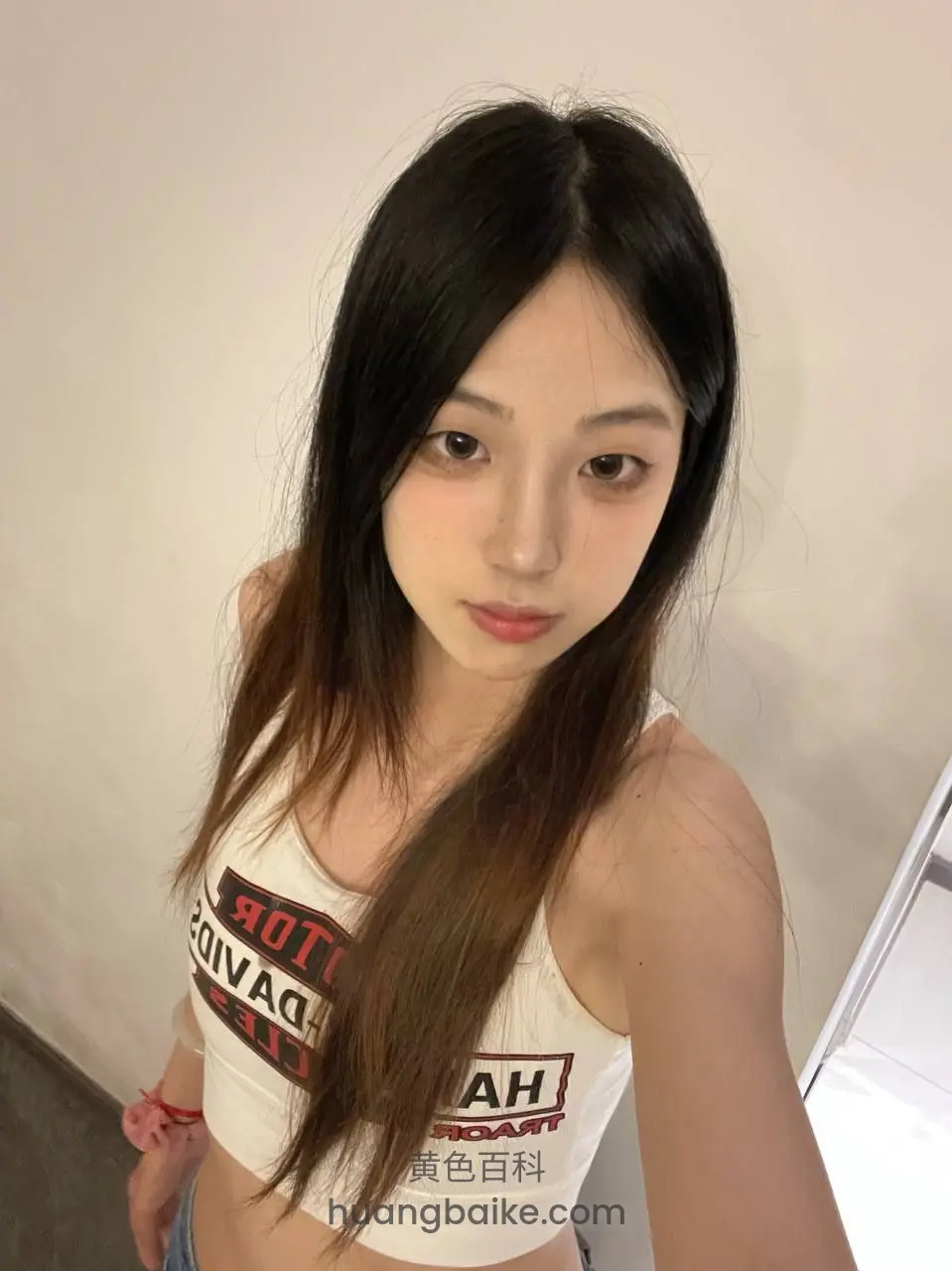 墙边举着手机自拍，露出腰部