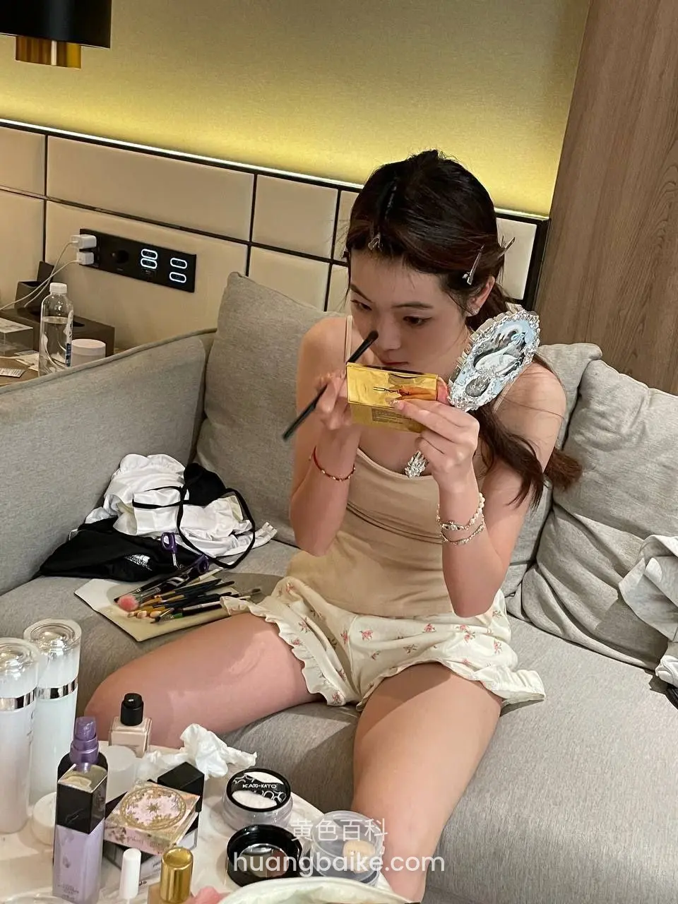 酒店沙发上涂口红，手里拿着金色盒子