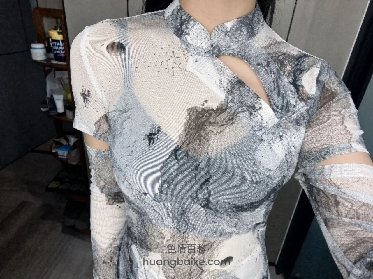 试衣间里举手机自拍，身上是灰白图案镂空旗袍