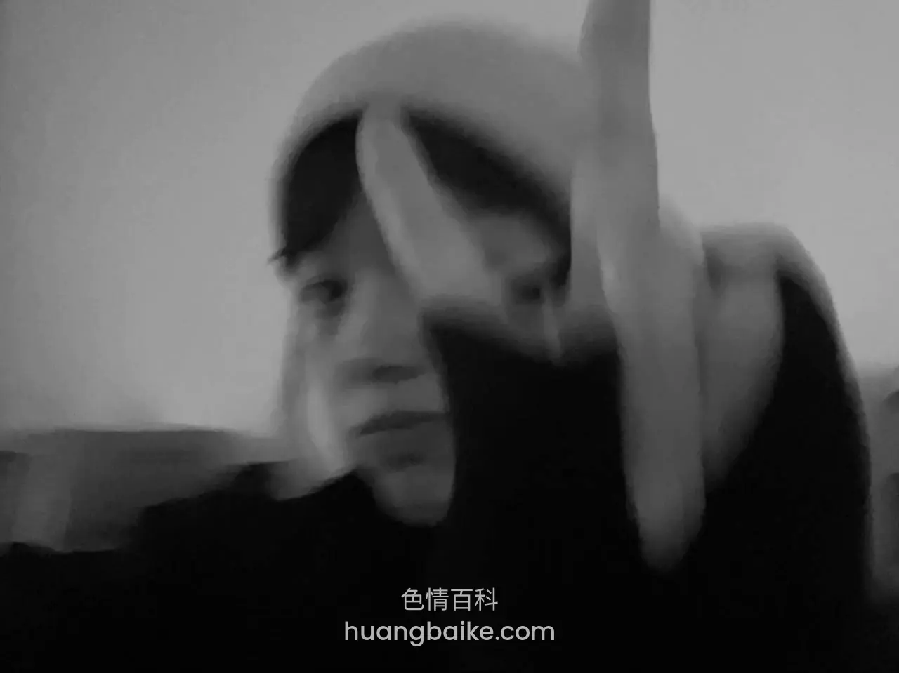 手举到镜头前挡着脸，眼睛看过来