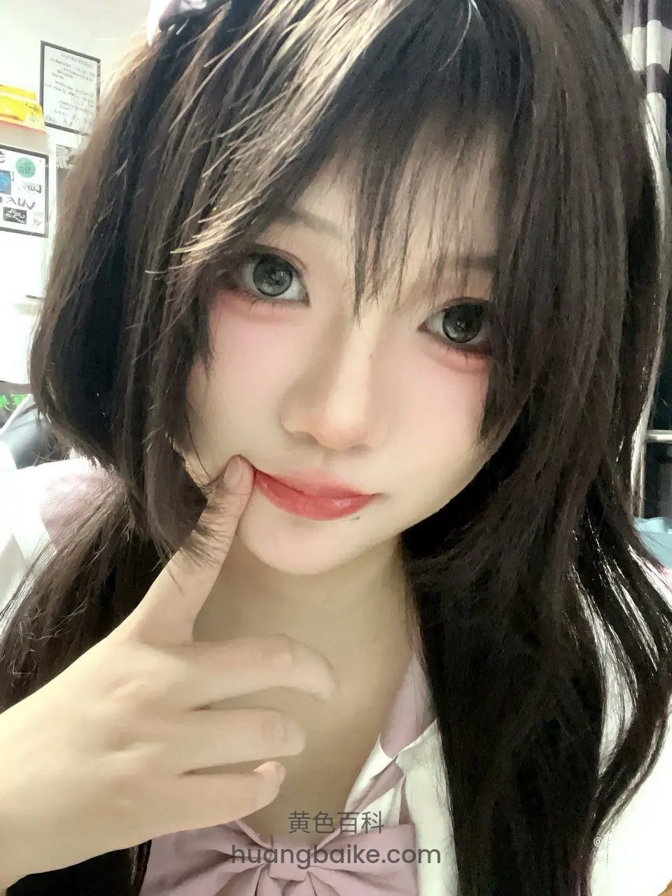 手指抵着下巴看镜头，脸部特写