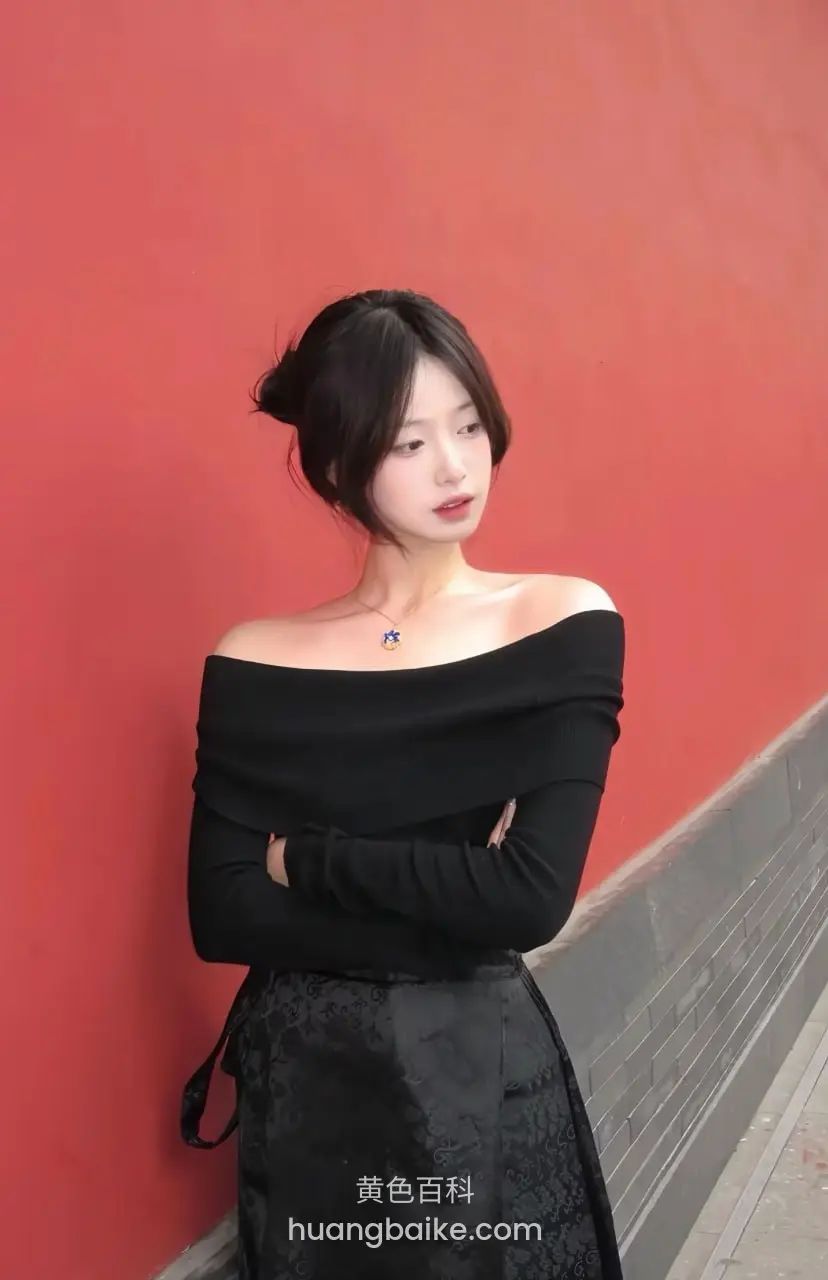 镜头对着红墙前交叉双臂