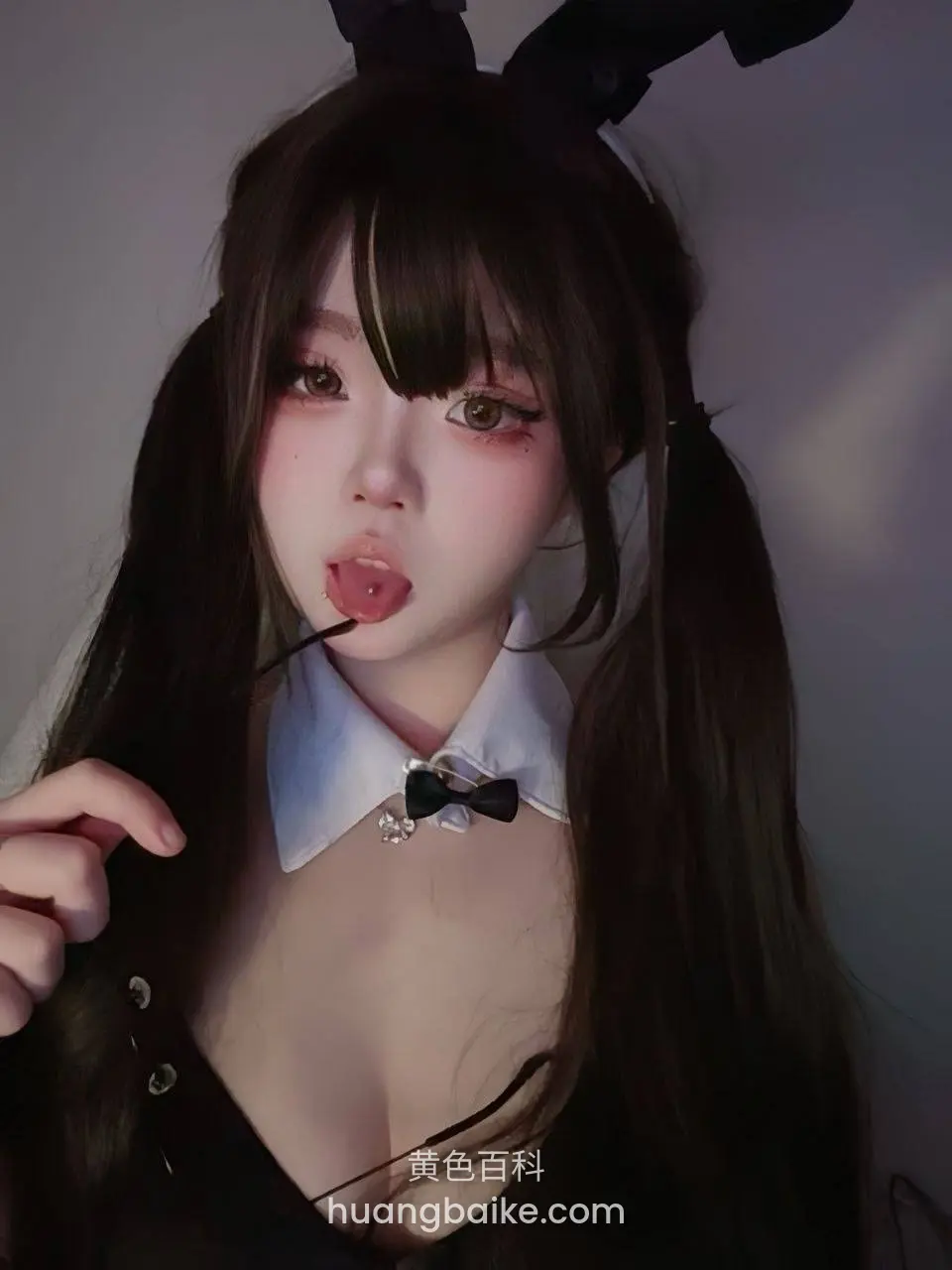 手里拉着衣服，舌头舔着棒棒糖