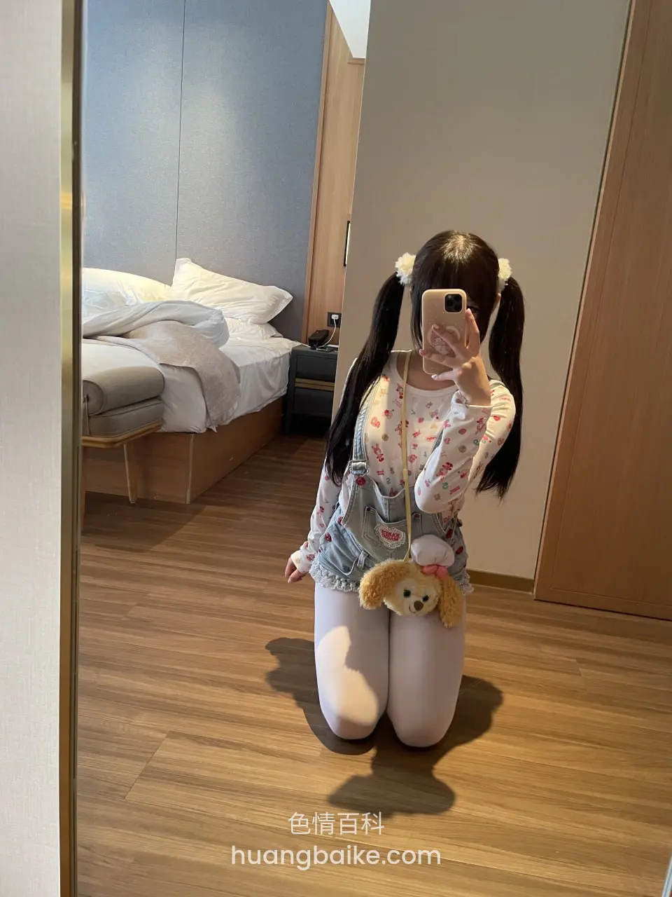 跪在木地板上，手机举过头顶