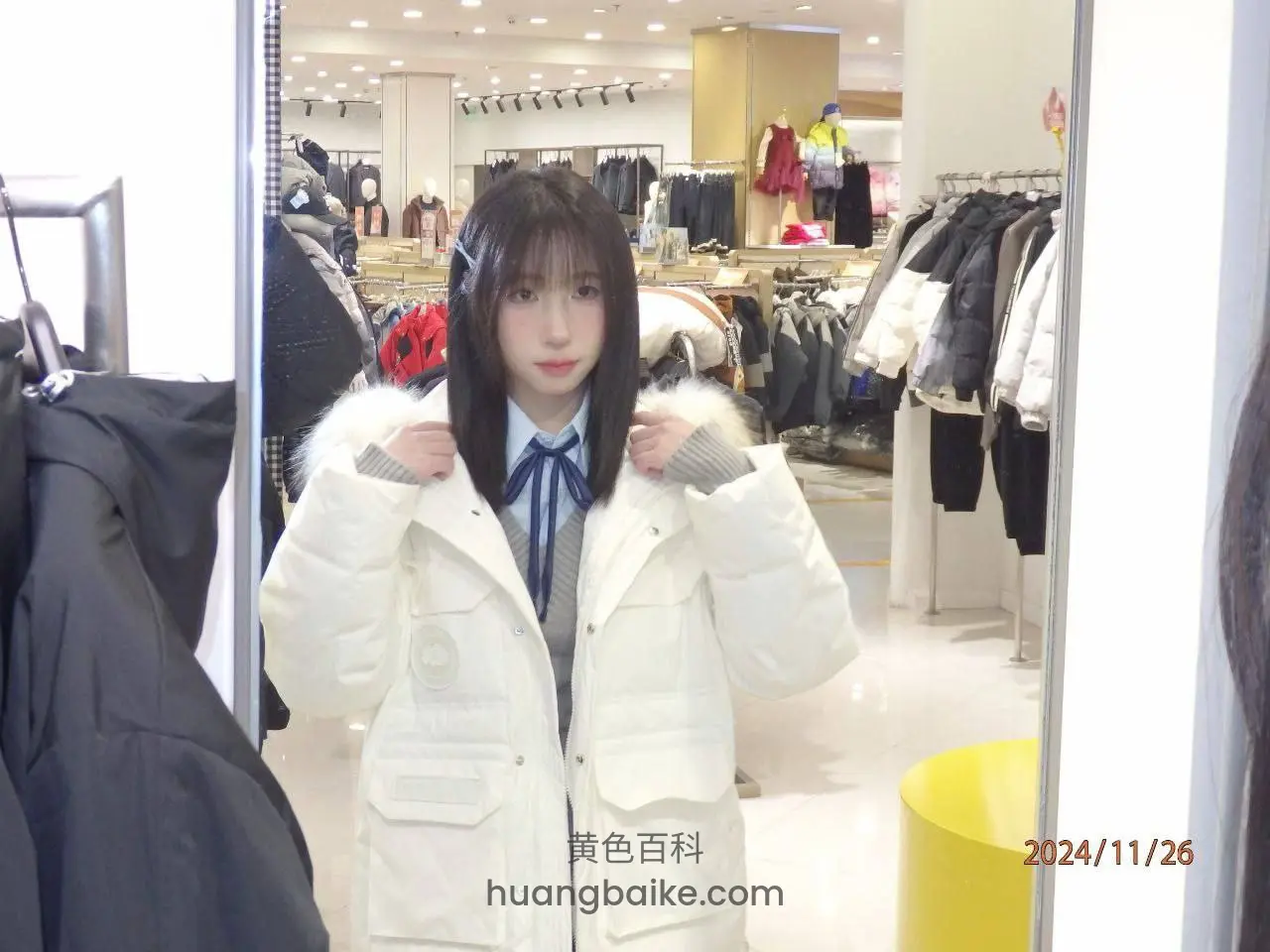 服装店镜子前试穿白羽绒服，双手拉着领口