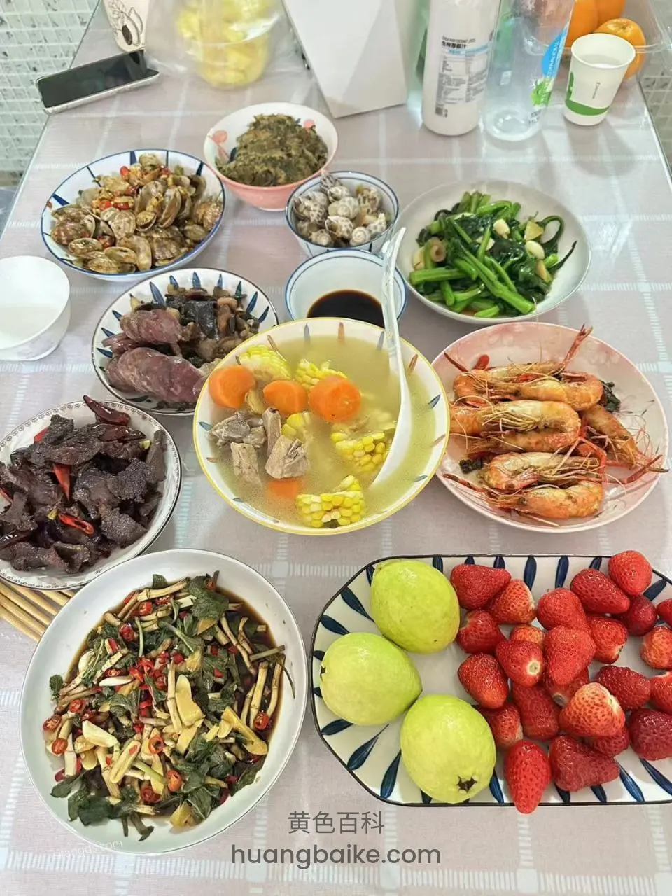 桌上摆满菜肴，有汤锅虾和草莓