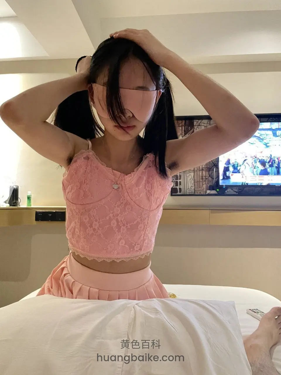 床上坐着双手举过头顶整理眼罩