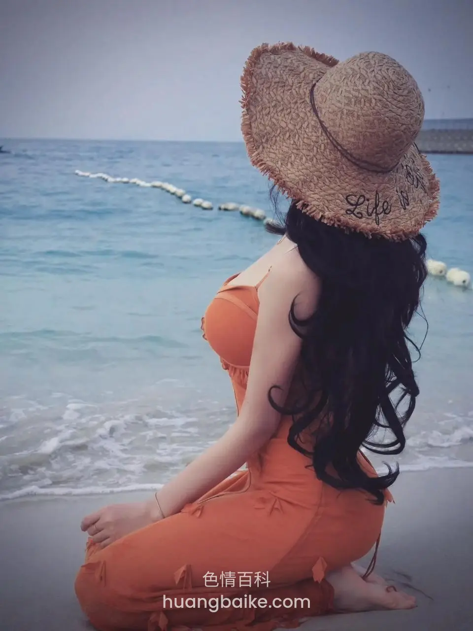 沙滩上跪坐望向大海，身后浪花和浮球绳