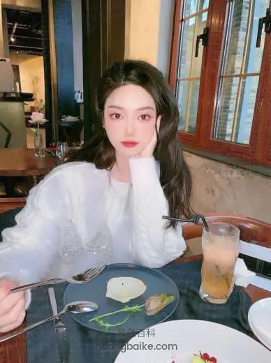 餐厅桌前托腮看镜头，手持刀叉