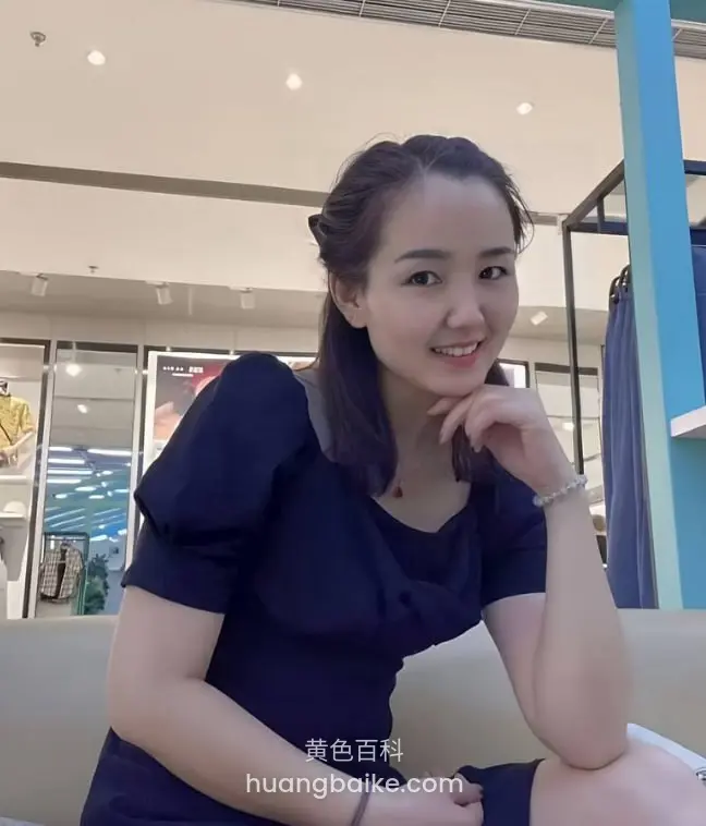 商场沙发上托着下巴，身后服装店橱窗