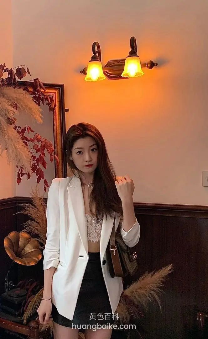 室内墙边站立握拳，身后壁灯亮着