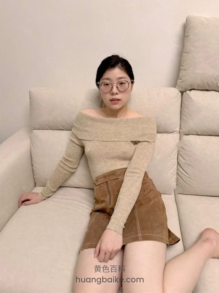 沙发上坐着，右手扶着沙发扶手