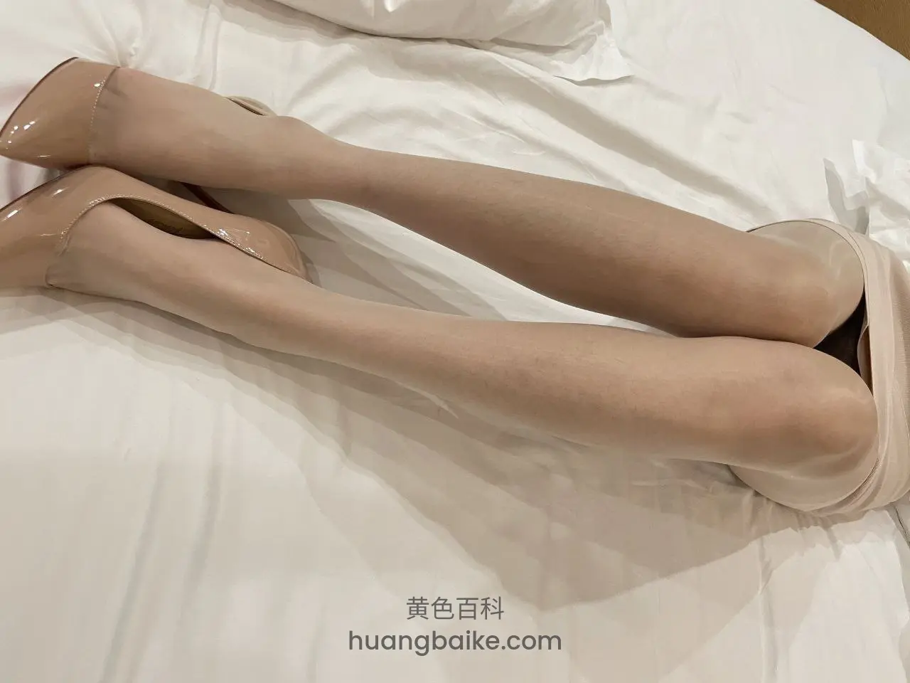 白床上伸直双腿，脚踩着高跟鞋
