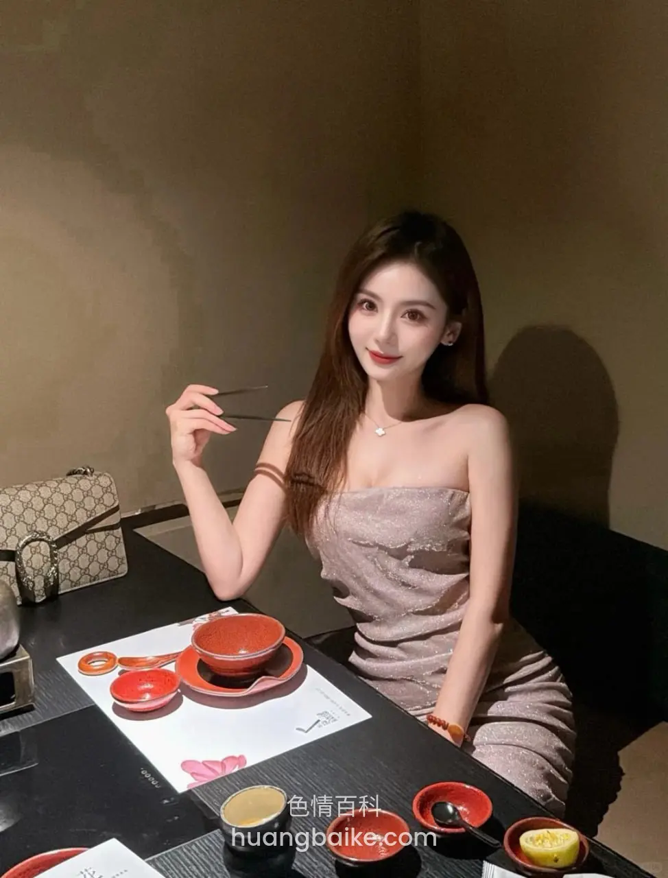 餐桌前拿筷子，桌上摆满餐具和菜，身后有Gucci包