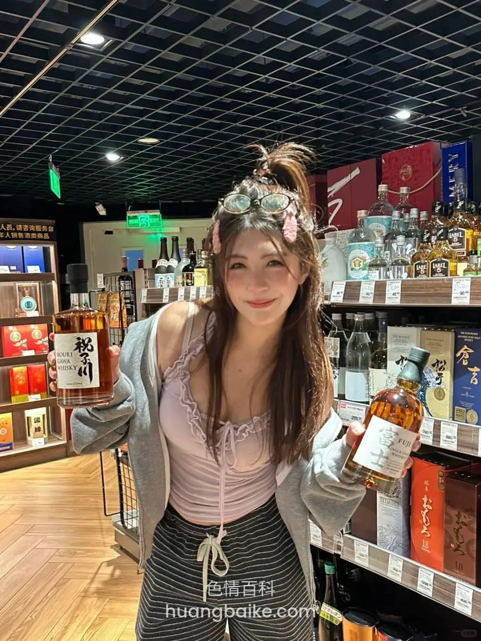 酒行货架前拿着两瓶威士忌