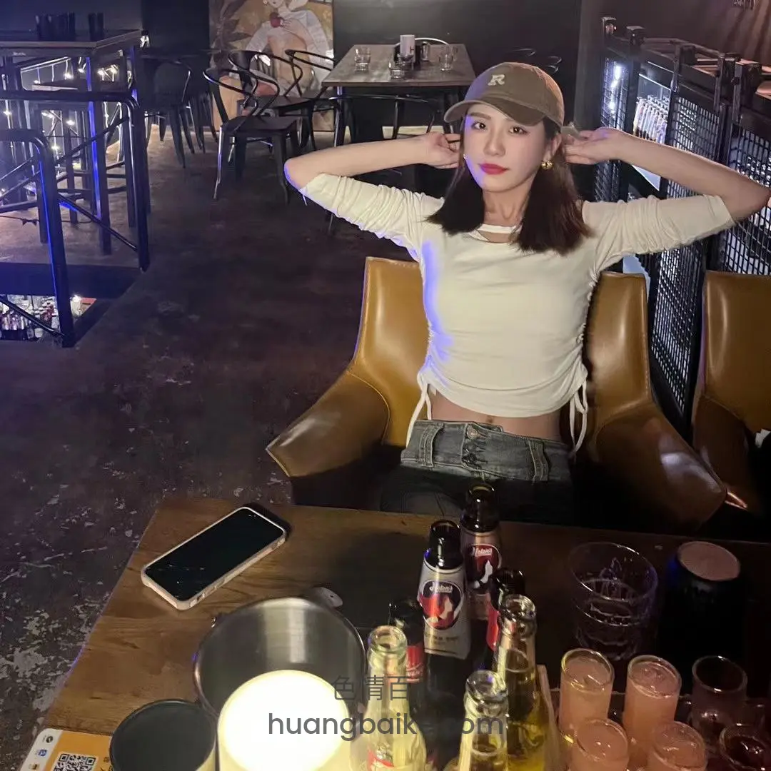 椅子上双手举过头顶，桌上手机和一堆啤酒瓶