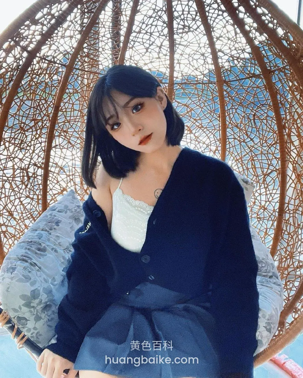 藤椅里低头看镜头