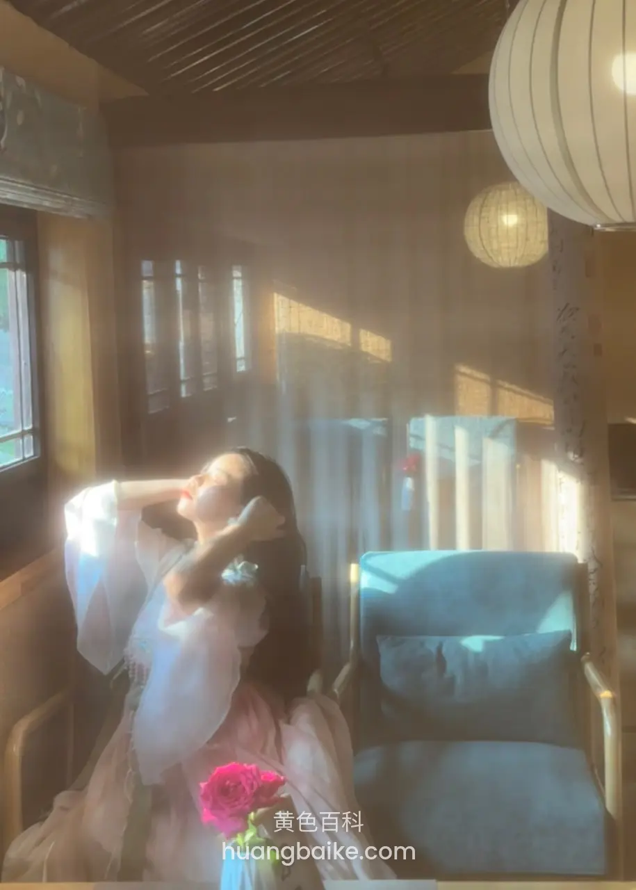 房间窗边拿着花束，镜头对着头顶吊灯