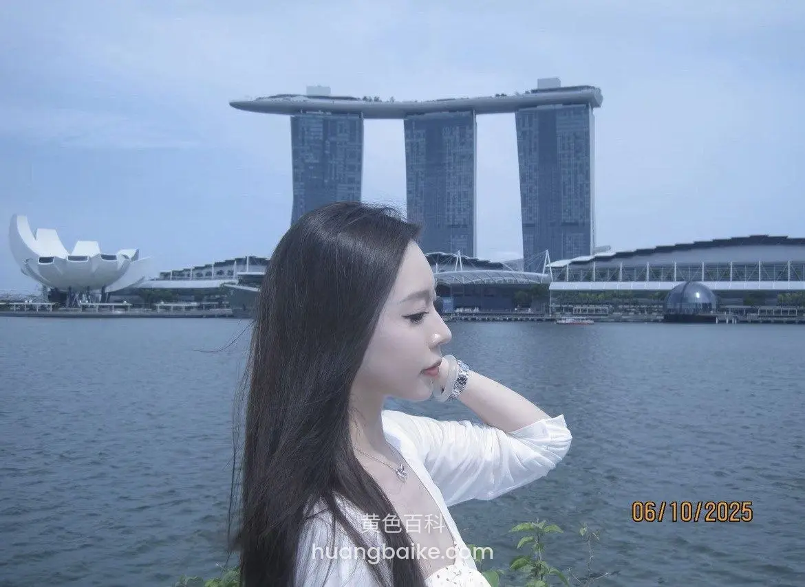 海边侧身站着看远处，手托下巴对着滨海湾