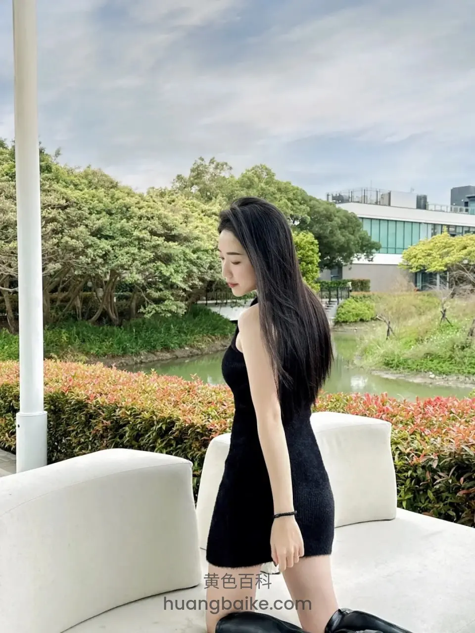 花园白沙发旁，回头望向身后绿树水景