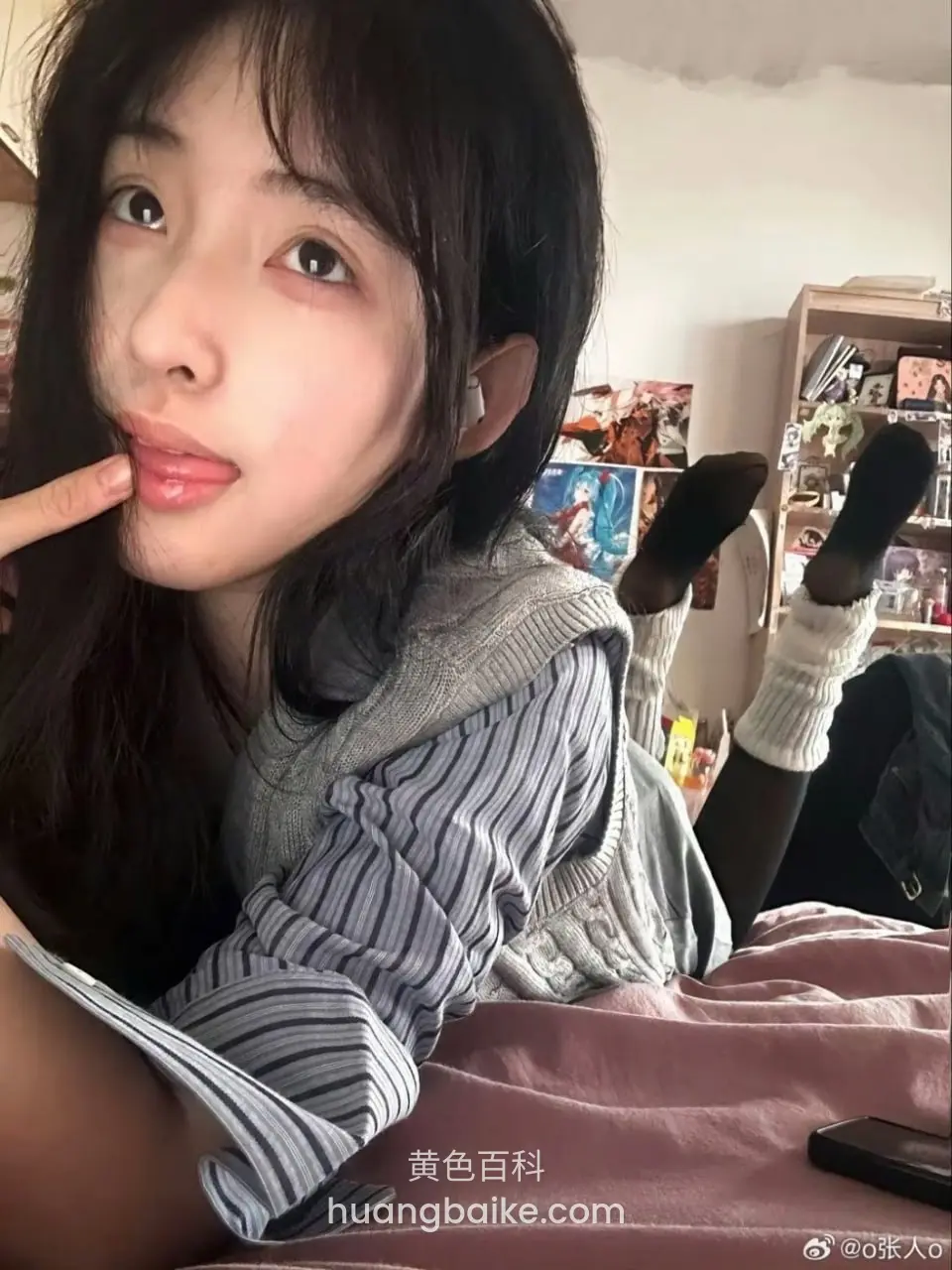 盘腿坐在床上，手指按着嘴唇