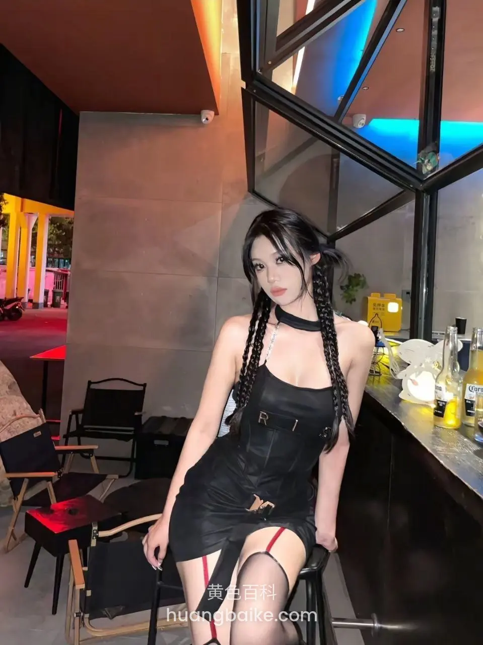 吧台前坐着，手扶高脚椅