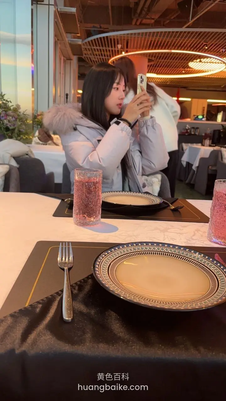 餐厅桌前举着手机自拍