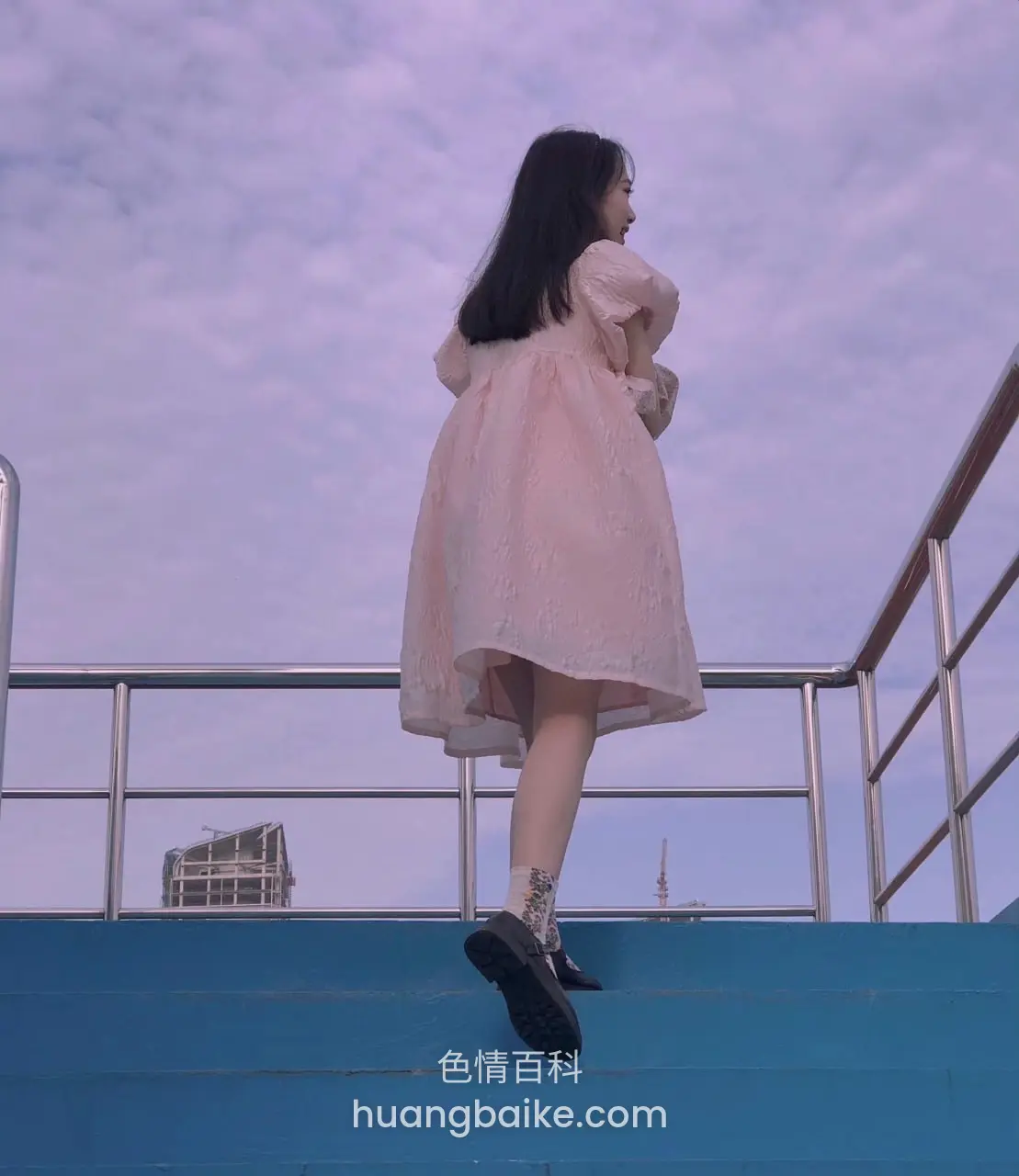 站在蓝色高台上回头看身后城市建筑