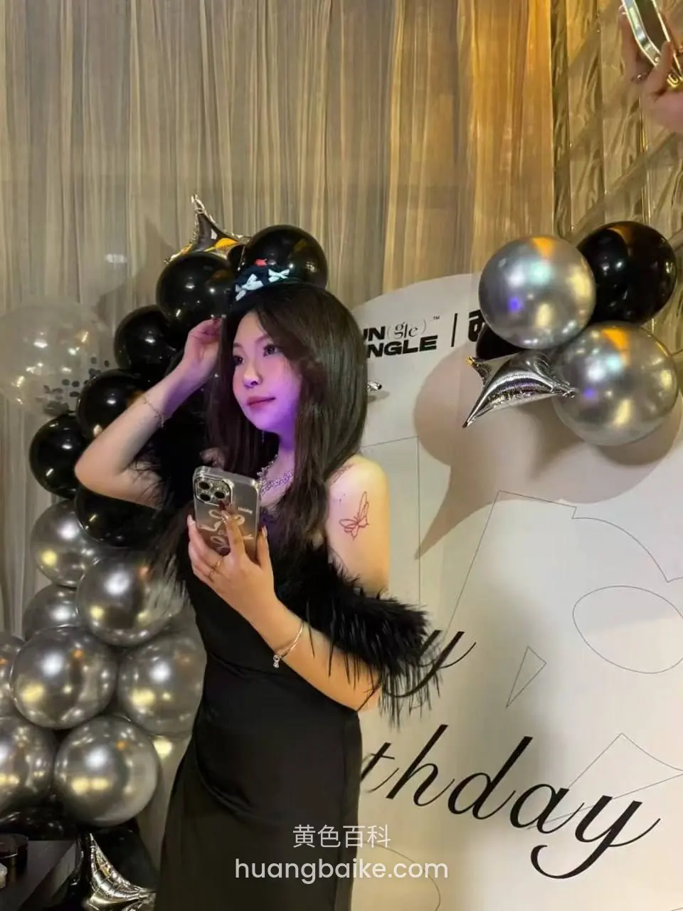 派对背景前拿着手机自拍，身后写着 birthday