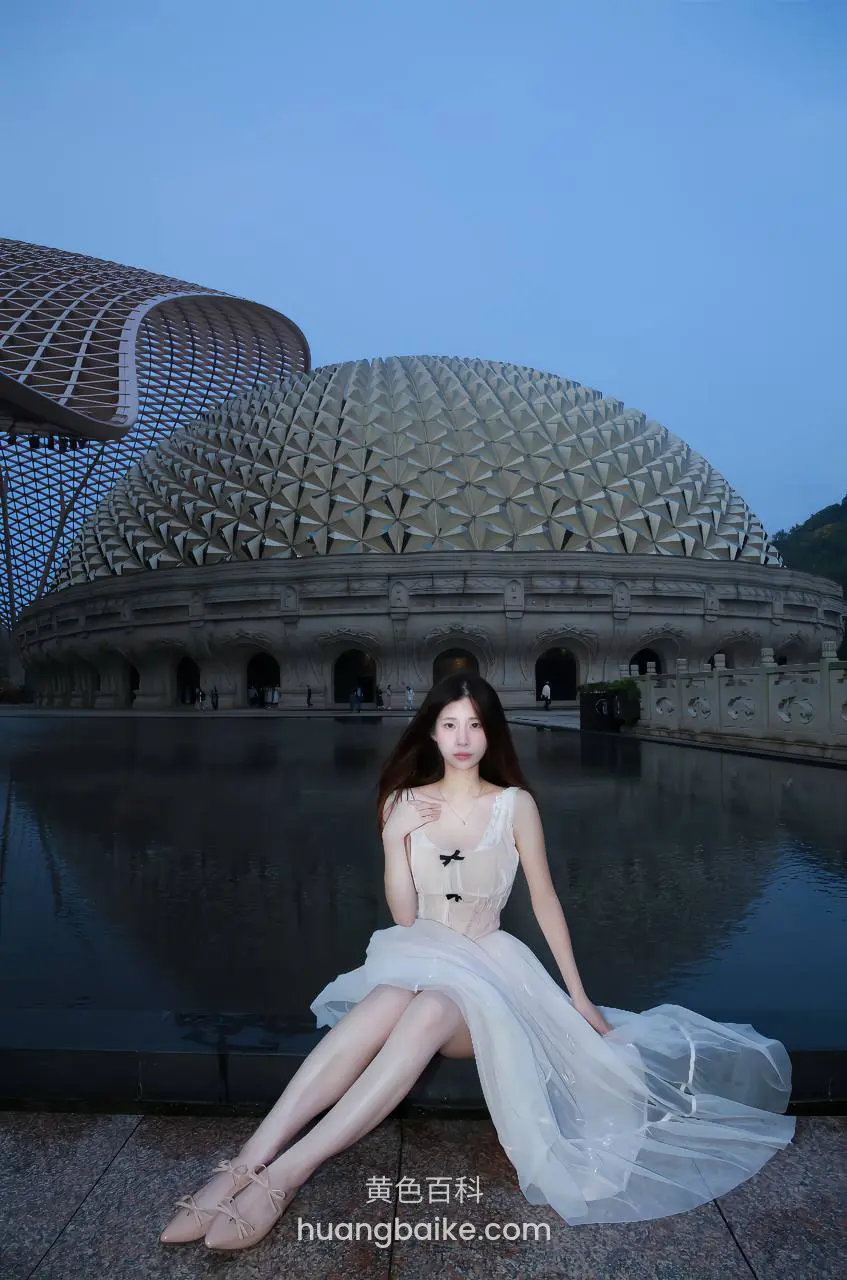 现代建筑前水池边坐着，身后是球形穹顶建筑