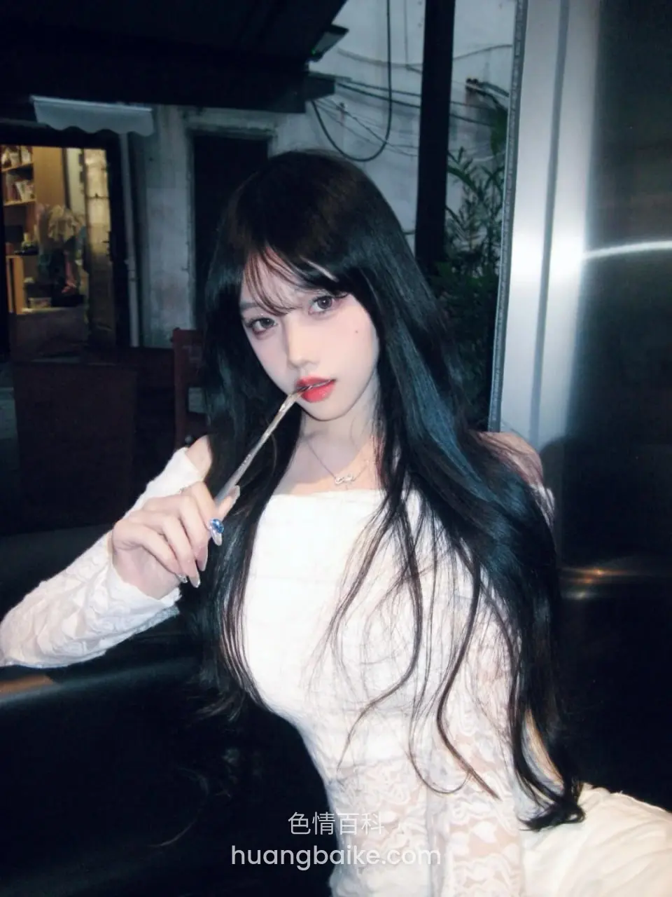 拿着吸管咬在嘴里，坐在沙发上回头看镜头