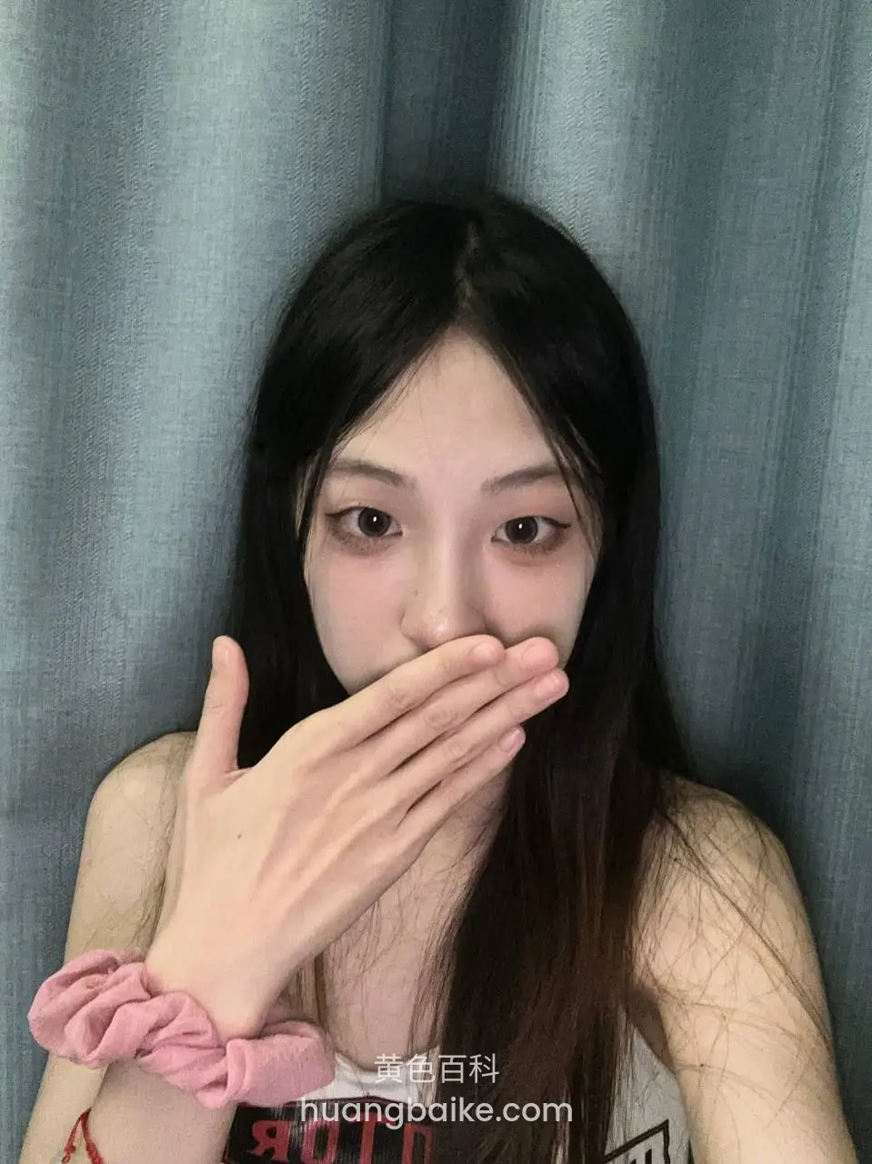 手捂住嘴，粉色发圈戴在手腕