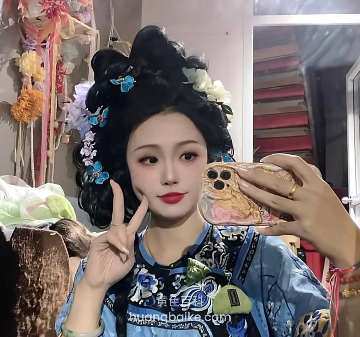对着镜头比耶，另一手举着手机自拍