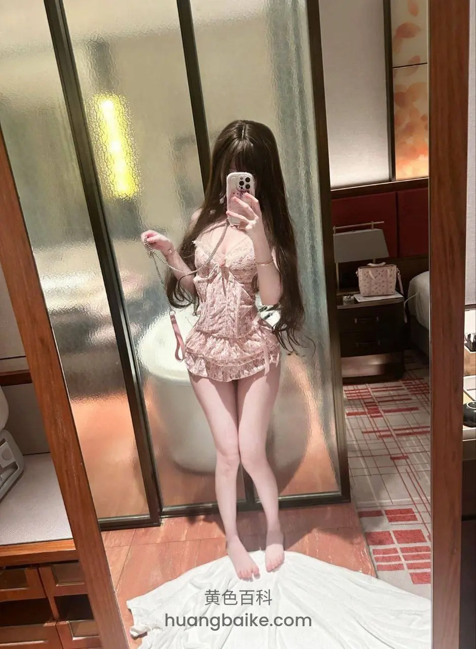 酒店房间镜子前拿手机自拍，身后浴缸和床