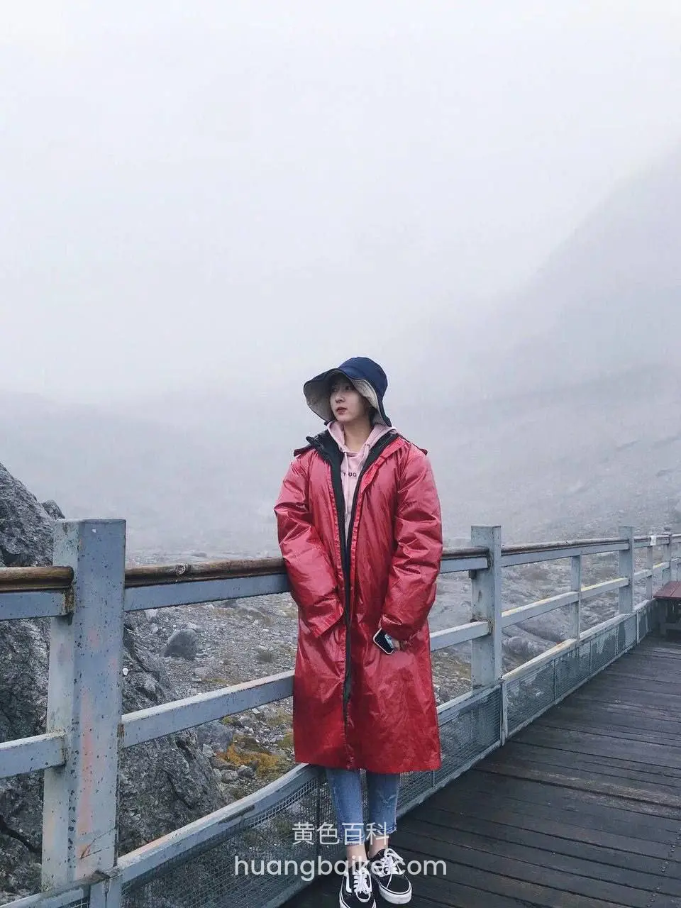 山顶木栈道雾气里站着，手插口袋