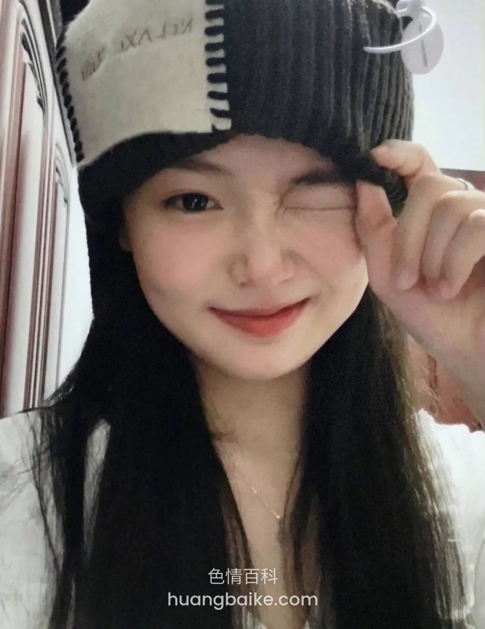 wink at camera pulling beanie down over one eye