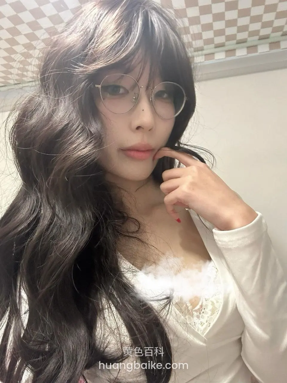 手指抵着下巴看镜头，头顶格子天花板