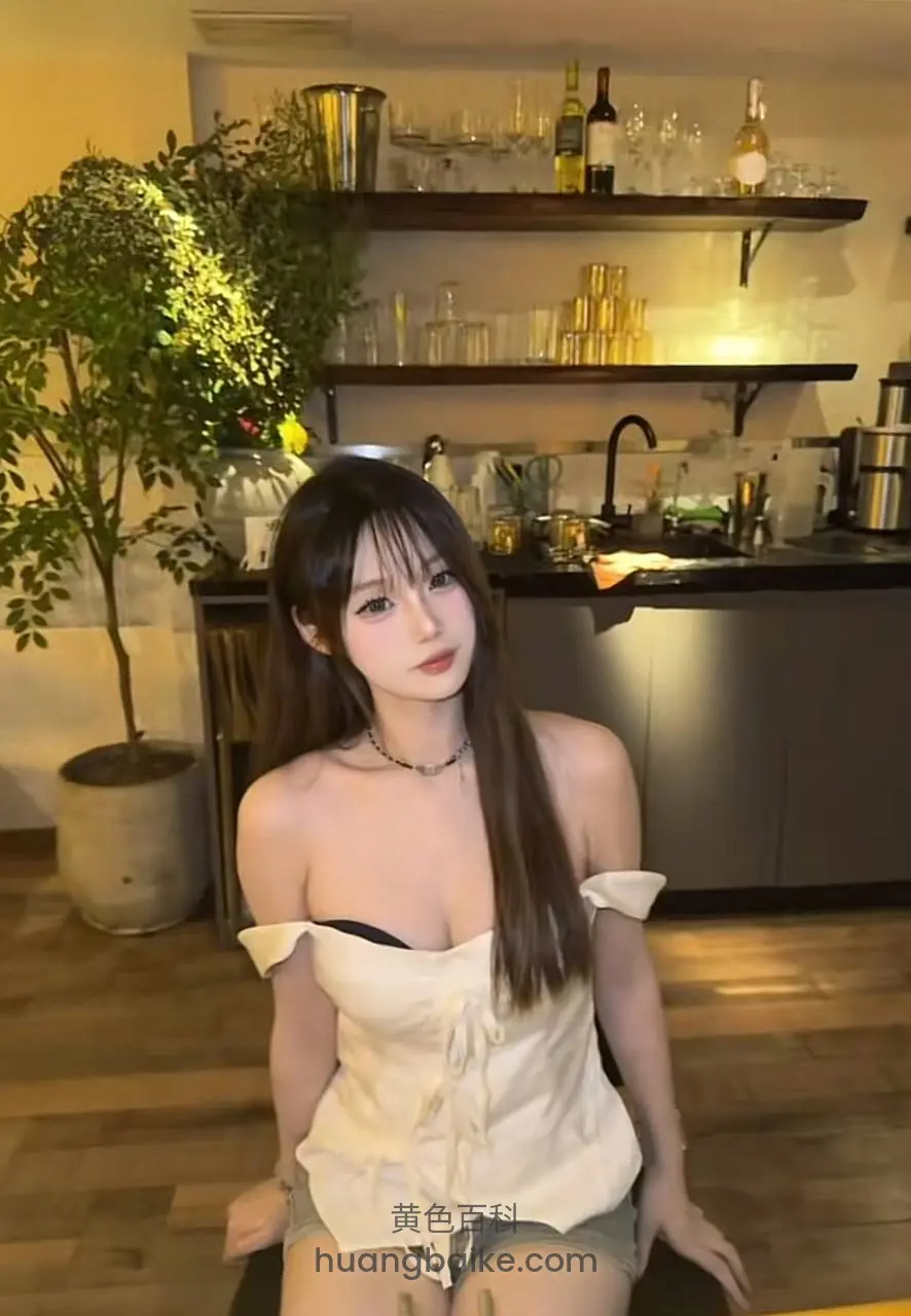 厨房地板上坐着，身后酒架和绿植