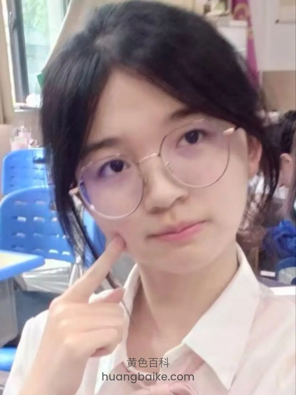 教室里指着脸颊看镜头
