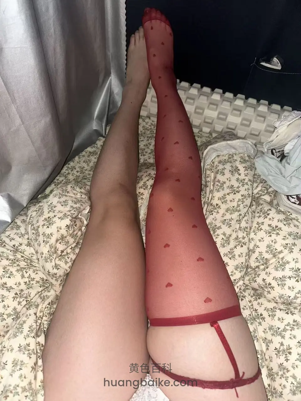 床上举着腿穿红心丝袜