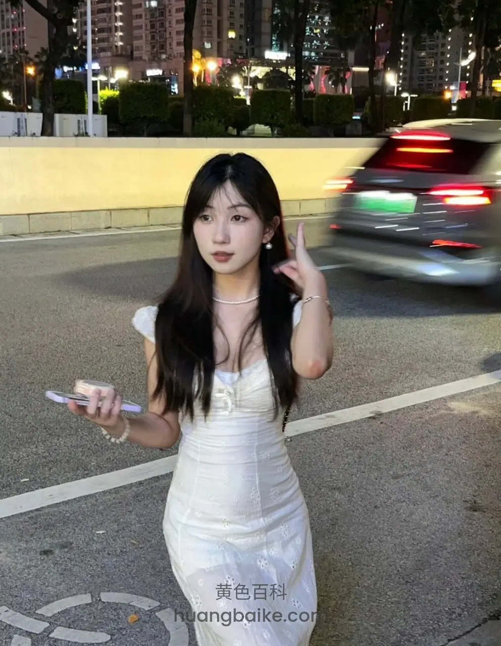 路边举手机比耶，身后车子开过