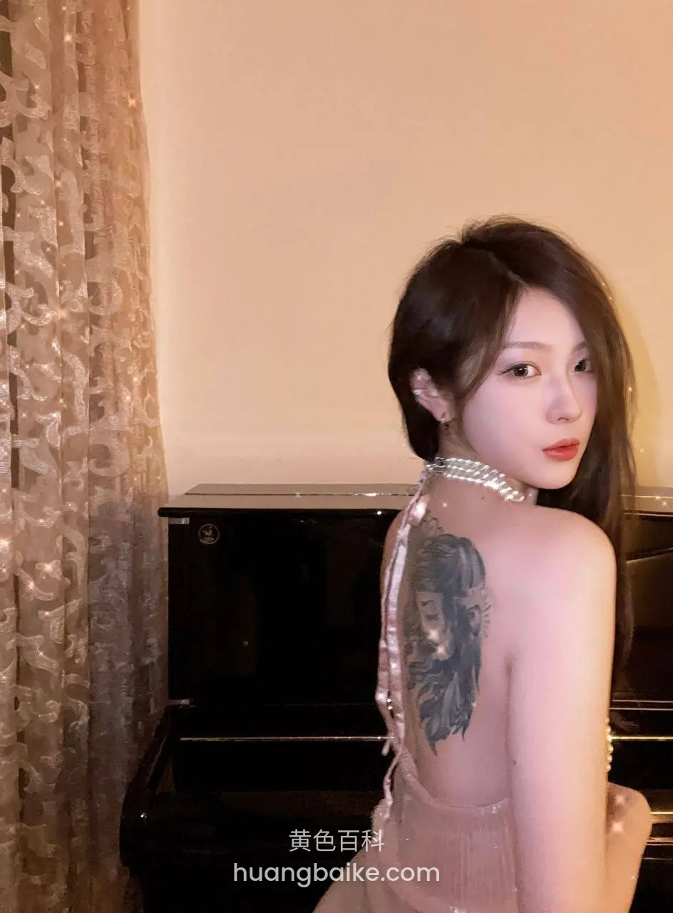 背对镜头回头看，背后大纹身和钢琴