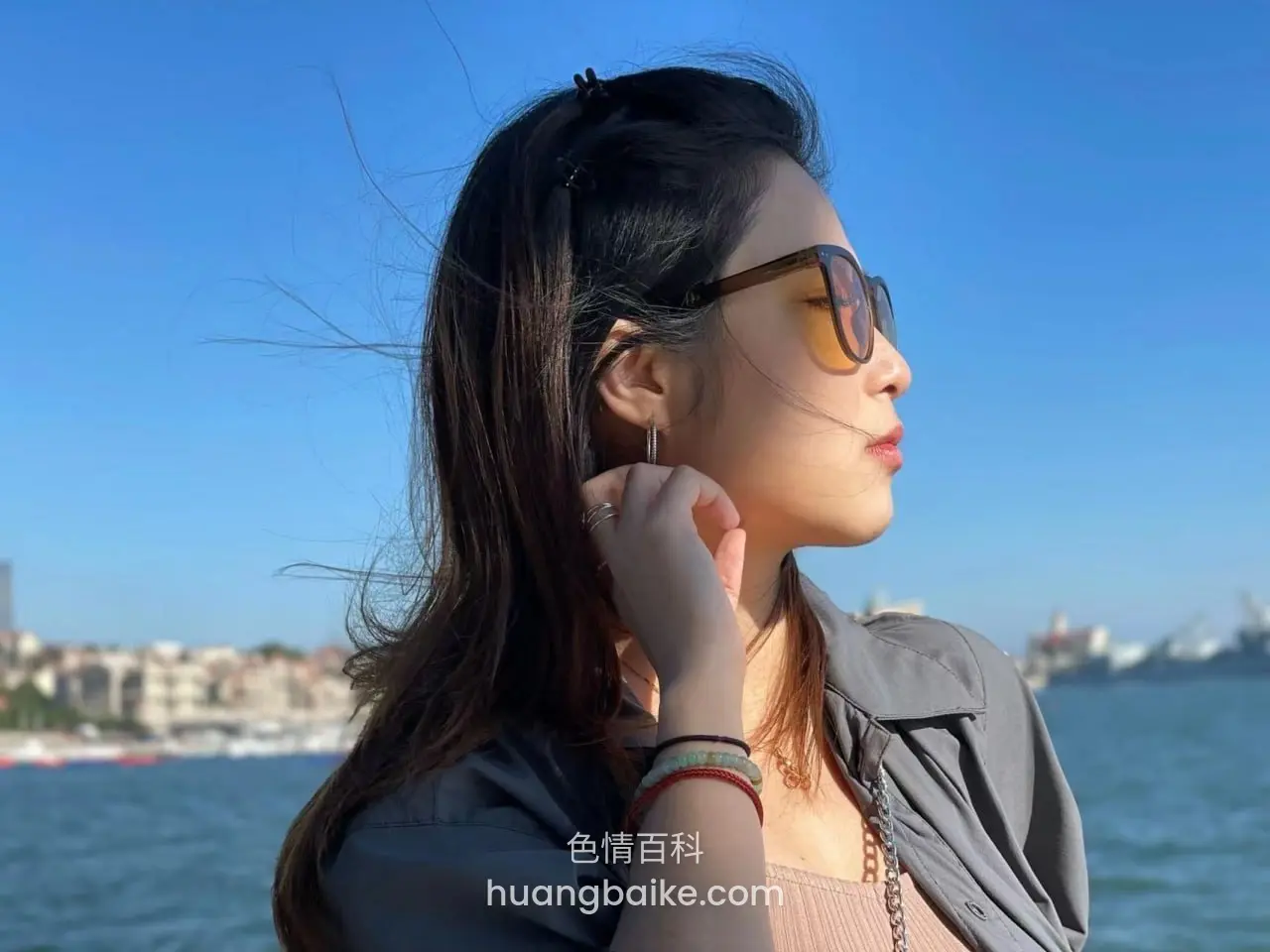 海边侧脸望远方，手扶耳边发丝