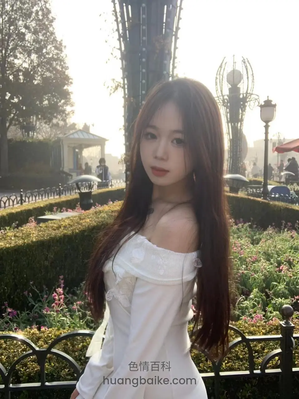 花园长椅前回头看镜头，身后有花坛