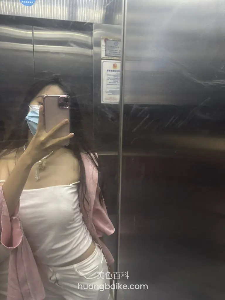 电梯镜子前举手机自拍，戴口罩和项链