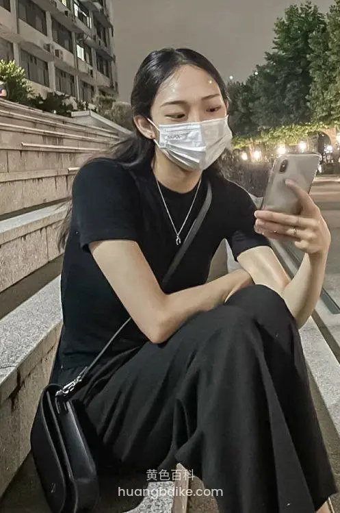 台阶上坐着玩手机，戴口罩挎包